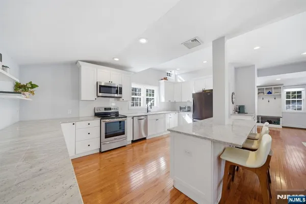 a living room with furniture a flat screen tv and kitchen view
