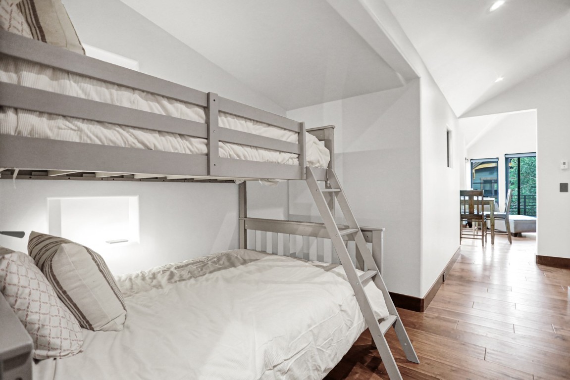 150 Game Trail Road Silverthorne, CO 80498 - Photo 38 of 47 a bedroom with a bed next to a large window with wooden floor