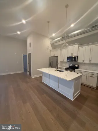 a kitchen with kitchen island sink stove and white cabinets