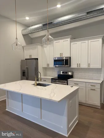 a kitchen with a refrigerator a sink and cabinets