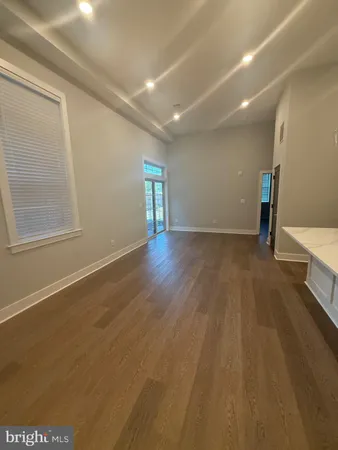 an empty room with wooden floor and entrance