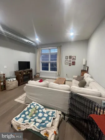 a living room with furniture a flat screen tv and a table