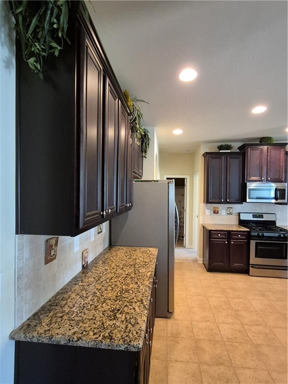 2269 Reddy Farm Lane Grayson, GA 30017 - Photo 20 of 46 a kitchen with stainless steel appliances granite countertop a stove top oven a sink and a refrigerator