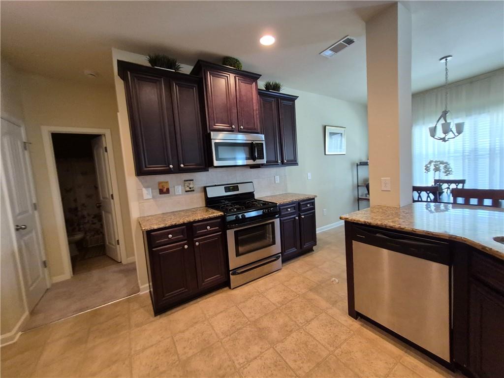2269 Reddy Farm Lane Grayson, GA 30017 - Photo 22 of 46 a kitchen with stainless steel appliances granite countertop a stove a sink and a refrigerator