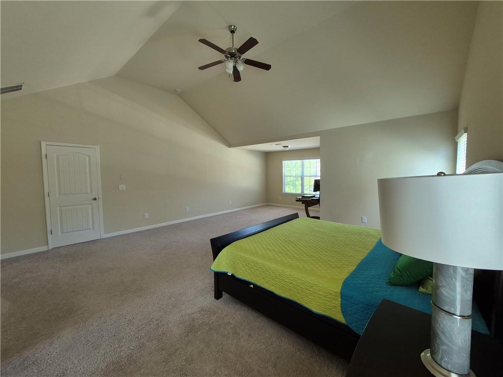 2269 Reddy Farm Lane Grayson, GA 30017 - Photo 34 of 46 a bedroom with a bed chandelier and a window