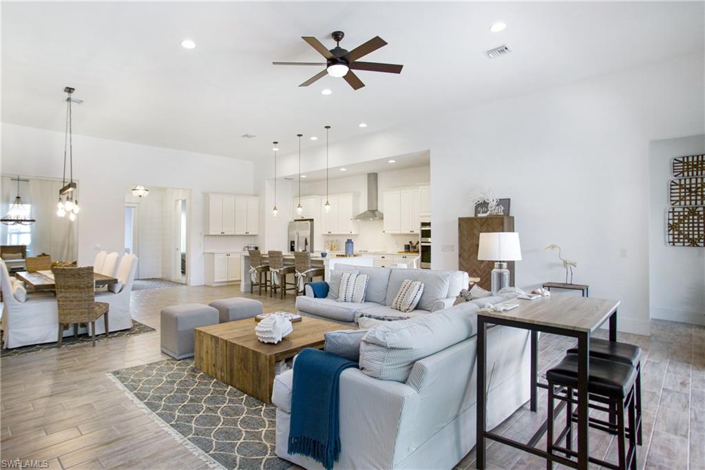 14856 Dockside Lane Naples, FL 34114 - Photo 16 of 50 a living room with furniture kitchen view and a chandelier