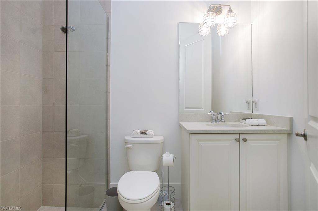 14856 Dockside Lane Naples, FL 34114 - Photo 32 of 50 a bathroom with a toilet a sink and mirror