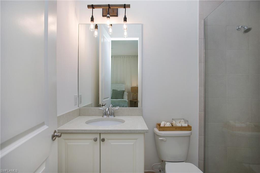 14856 Dockside Lane Naples, FL 34114 - Photo 35 of 50 a bathroom with a sink and mirror with toilet