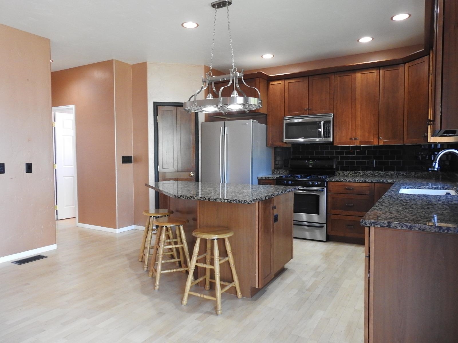 1601 Anvil View Avenue Rifle, CO 81650 - Photo 7 of 35 a kitchen with stainless steel appliances granite countertop wooden cabinets a stove top oven a sink and dishwasher
