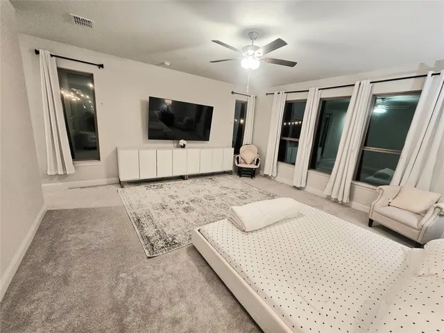 a bedroom with a large bed and a flat screen tv