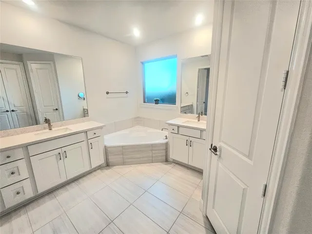 a large white bathroom with a granite countertop sink mirror and a