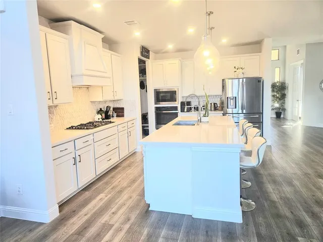 a kitchen with stainless steel appliances a stove a sink a refrigerator and cabinets