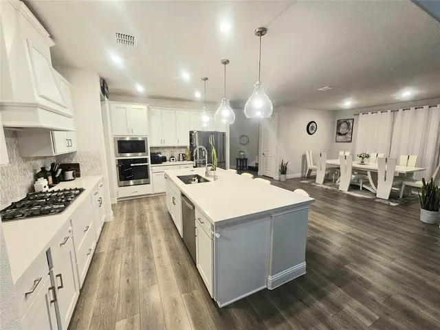 a large kitchen with a table and chairs