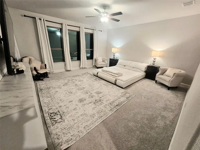 a bedroom with furniture and large windows