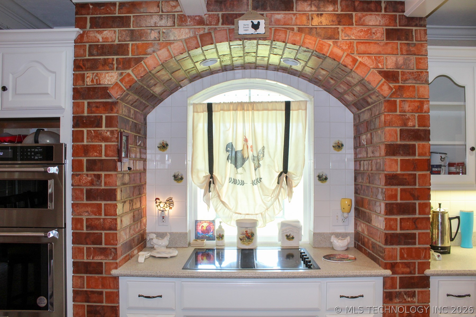13248 North 3540th Road Maud, OK 74854 - Photo 47 of 98 Brick archway framing a kitchen window with an integrated cooktop