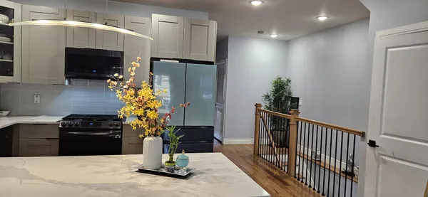 a kitchen with granite countertop a stove and a refrigerator