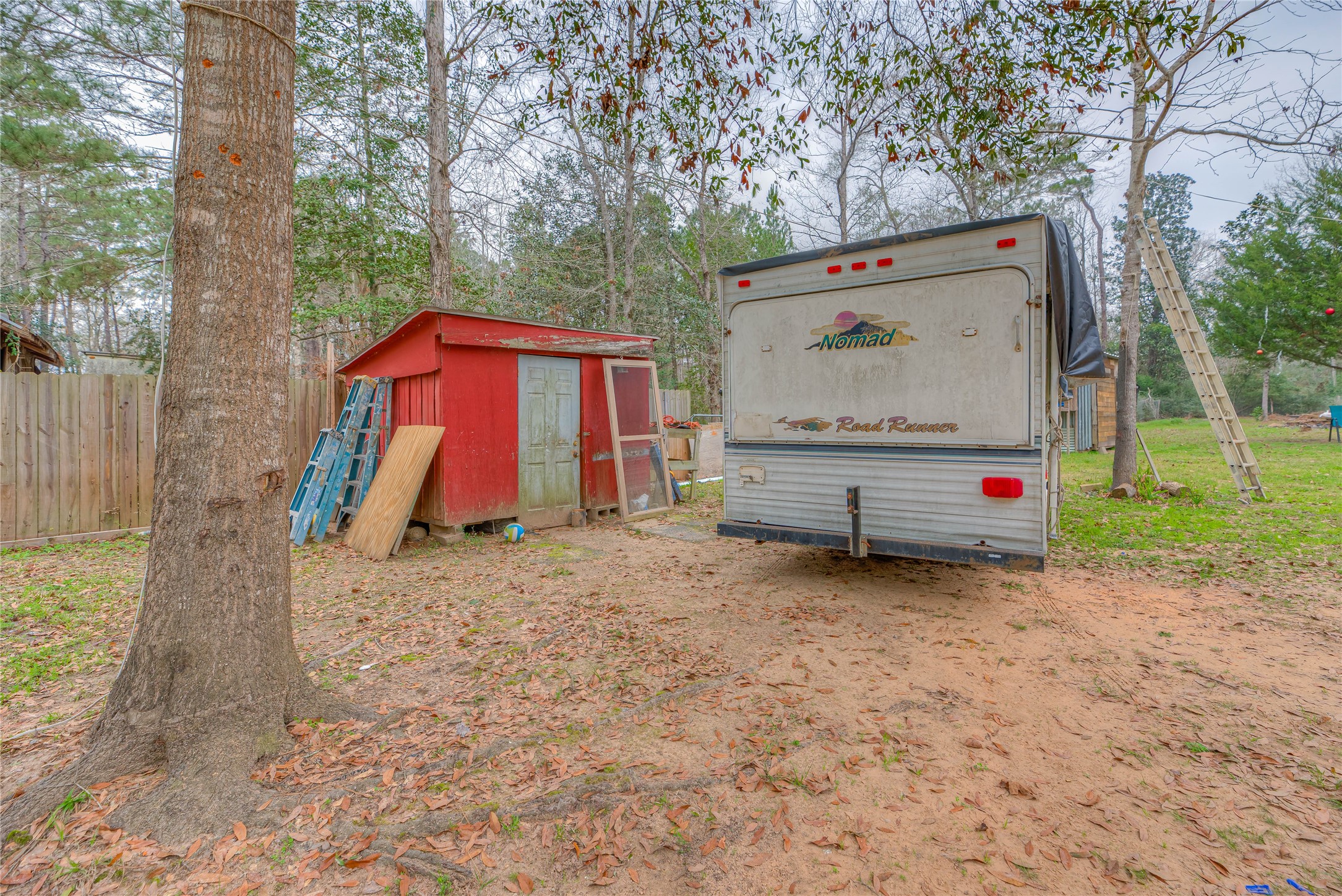 713 Garrett Road Livingston, TX 77351 - Photo 19 of 40 a view of backyard with wooden fence and a large tree