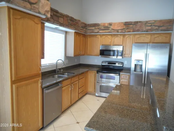 a kitchen with stainless steel appliances granite countertop a stove a sink and a refrigerator