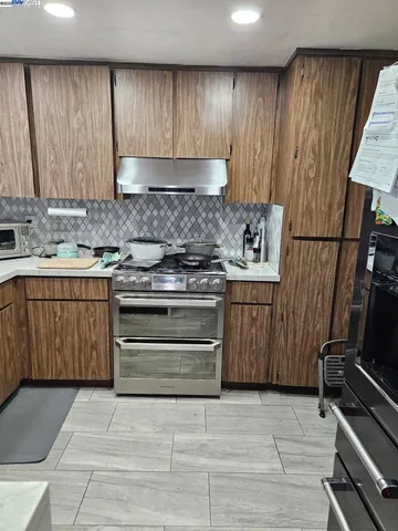 a kitchen with stainless steel appliances granite countertop a stove a sink and a refrigerator