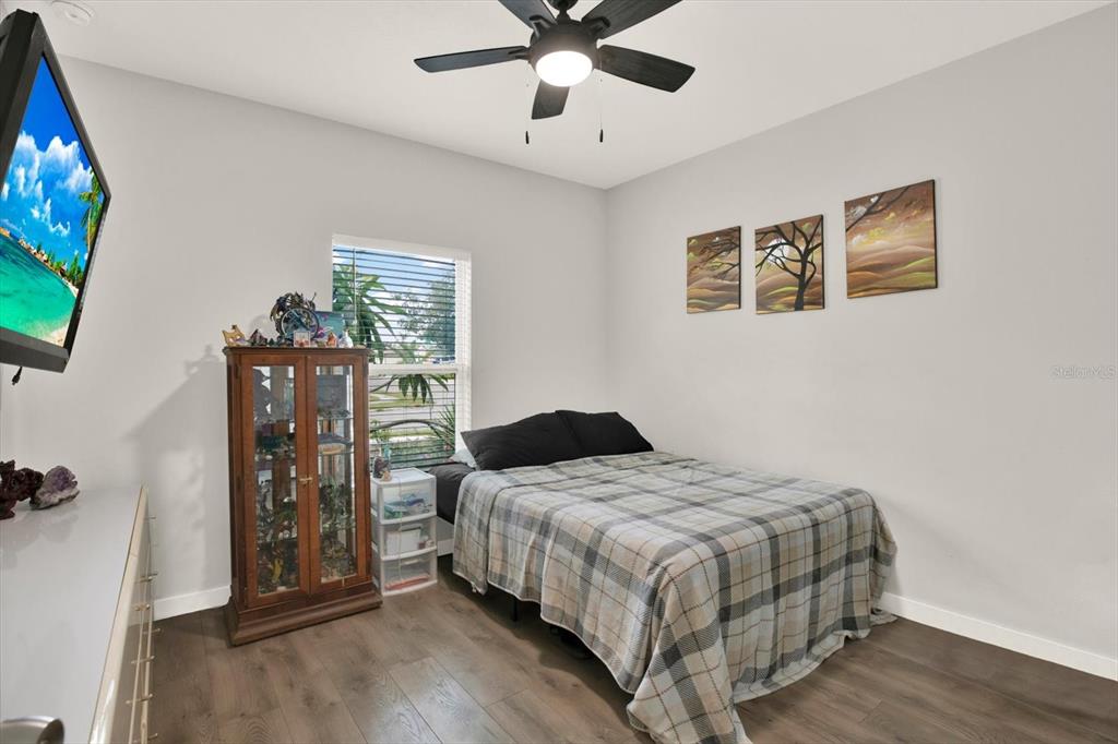 3023 Muir Street Holiday, FL 34691 - Photo 13 of 25 a bedroom with a bed and a flat tv screen on dresser