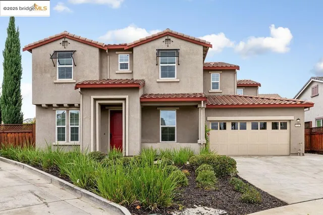 a view of a white house with large windows and a small yard