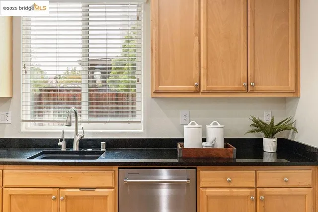 a kitchen with stainless steel appliances granite countertop a sink a window and a granite counter tops