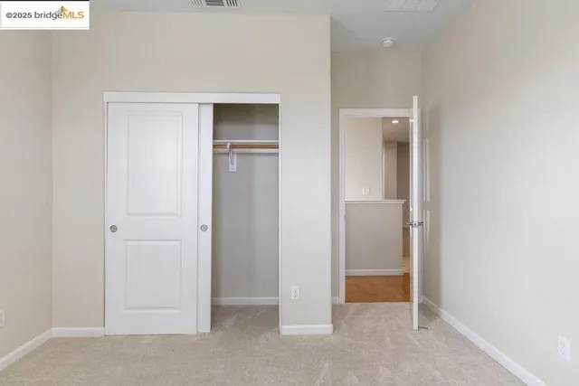 an empty room with closet and windows