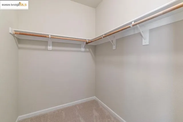 a bedroom with a bed lamp and a large window