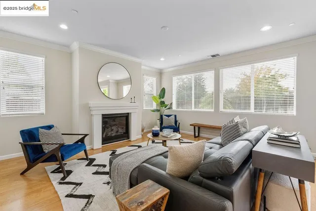 a living room with furniture a fireplace and floor to ceiling windows