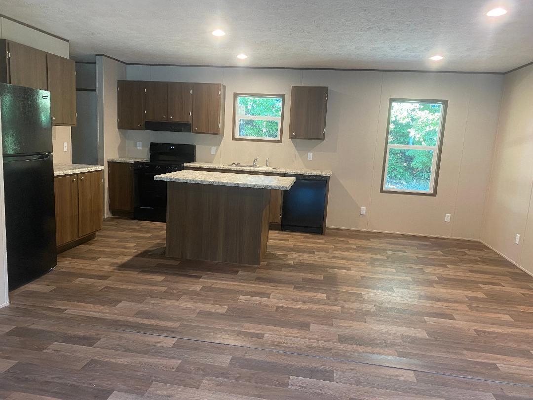 106 Simmons Road Munford, TN 38058 - Photo 27 of 30 Kitchen featuring wood-finish flooring, recessed lighting, wood-tone cabinetry, a central island with a countertop, and two windows