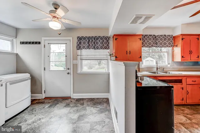 a view of kitchen with granite countertop cabinets and refrigerator
