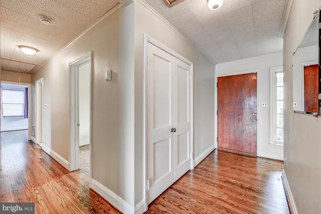 a view of a hallway with wooden floor and closet