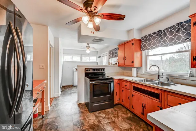 a kitchen with stainless steel appliances granite countertop a sink a stove and a refrigerator