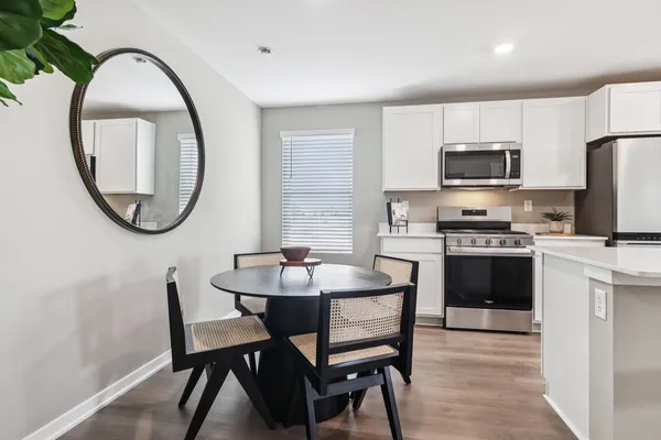a kitchen with a dining table chairs and a refrigerator