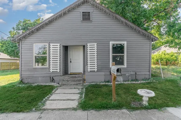 a front view of a house with garden and yard