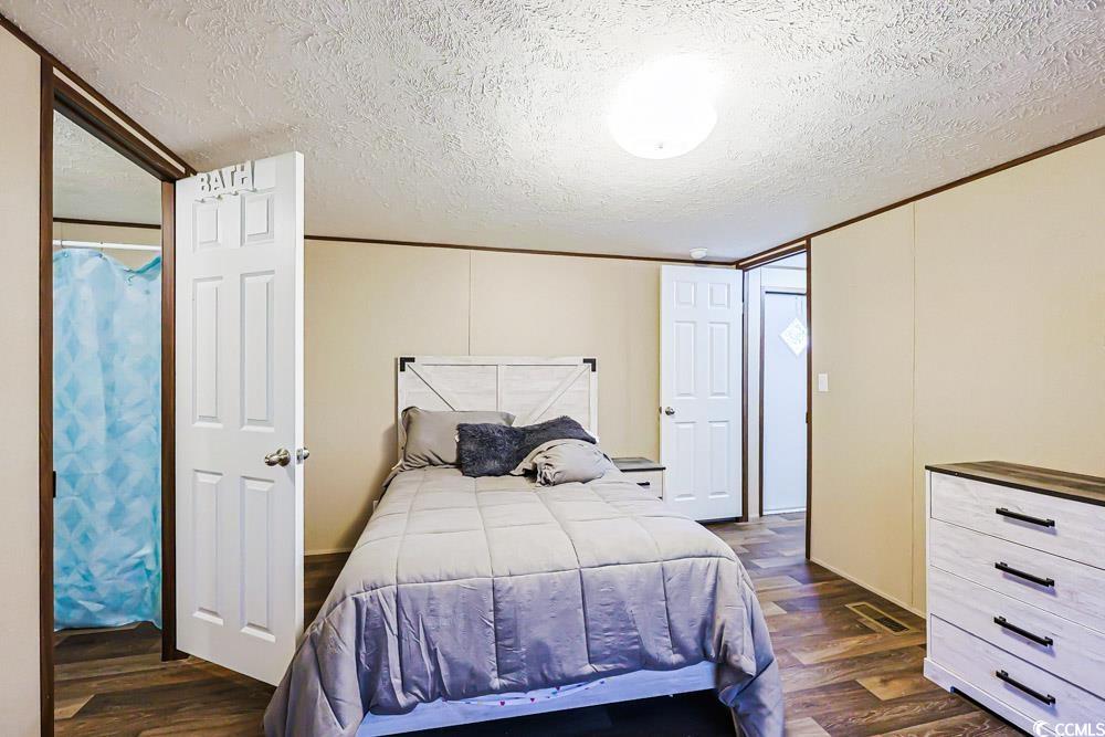 255 Quail Run Road Loris, SC 29569 - Photo 10 of 29 Bedroom with a textured ceiling and dark wood-style floors