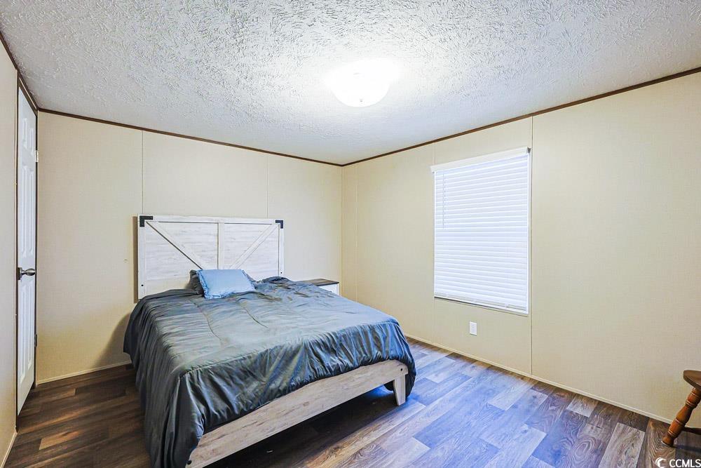 255 Quail Run Road Loris, SC 29569 - Photo 15 of 29 Bedroom featuring ornamental molding, a textured ceiling, and wood finished floors