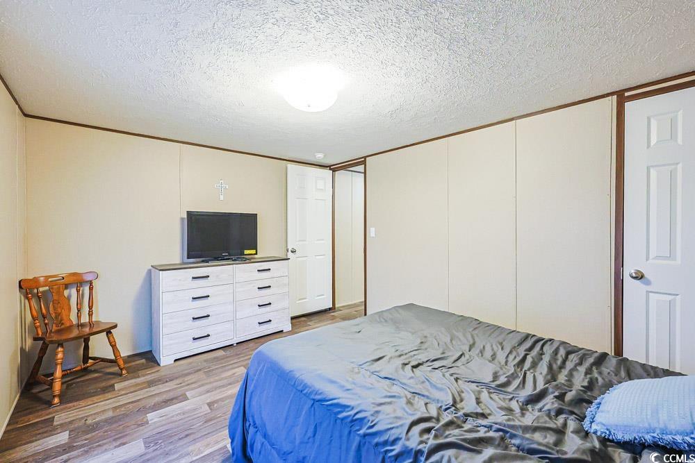 255 Quail Run Road Loris, SC 29569 - Photo 16 of 29 Bedroom featuring a textured ceiling and wood finished floors
