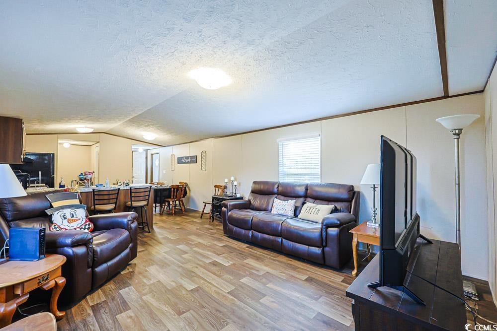 255 Quail Run Road Loris, SC 29569 - Photo 2 of 29 Living room featuring light wood-style floors, vaulted ceiling, and a textured ceiling
