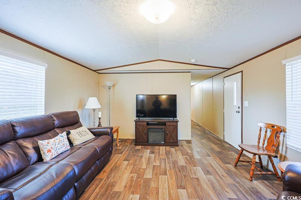 255 Quail Run Road Loris, SC 29569 - Photo 4 of 29 Living room featuring vaulted ceiling, ornamental molding, wood finished floors, healthy amount of natural light, and a textured ceiling