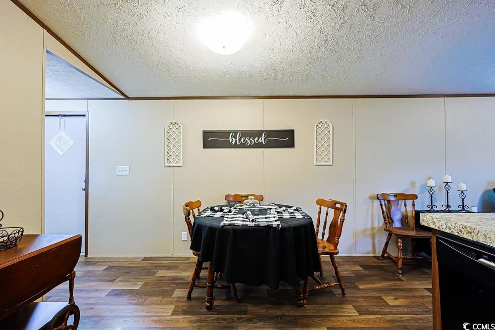 255 Quail Run Road Loris, SC 29569 - Photo 6 of 29 Dining area featuring a textured ceiling, dark wood finished floors, a decorative wall, and ornamental molding