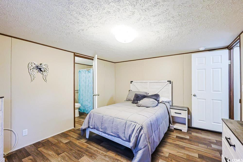 255 Quail Run Road Loris, SC 29569 - Photo 8 of 29 Bedroom with wood finished floors, a textured ceiling, crown molding, and ensuite bathroom