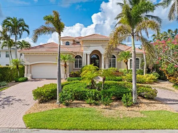a front view of a house with a yard and potted plants