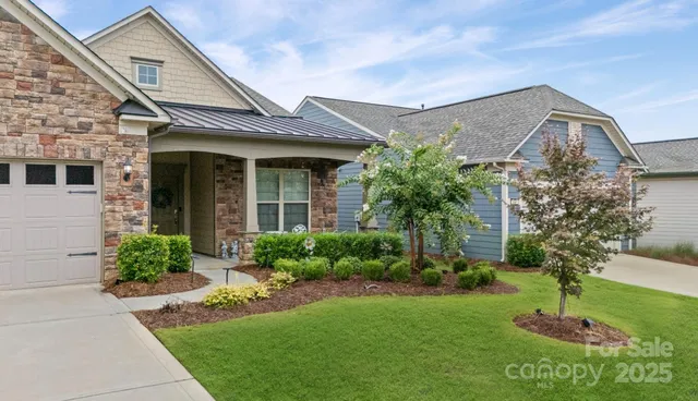 a front view of a house with a garden and plants