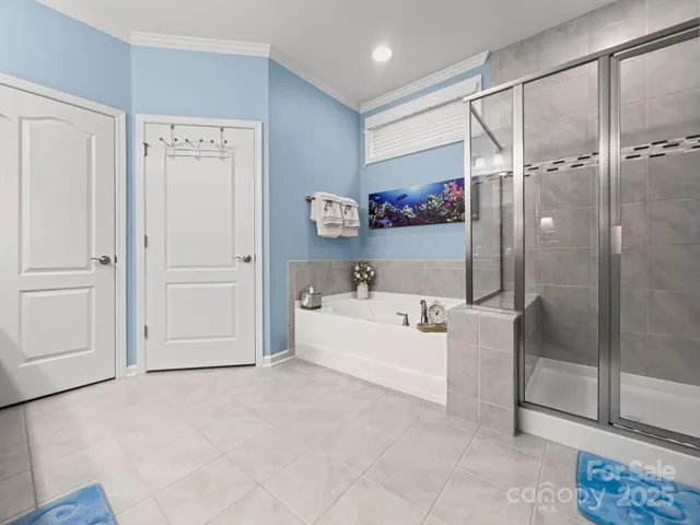 a spacious bathroom with a tub shower and mirror