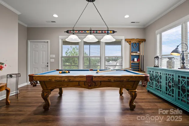a room with pool table and windows