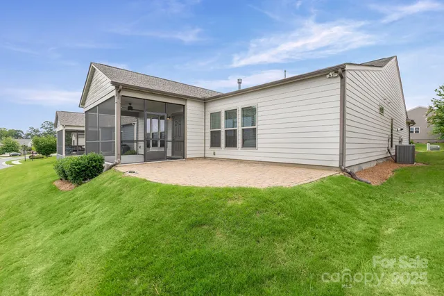 a view of a backyard with plants and large tree