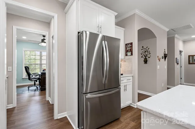 a kitchen with stainless steel appliances a refrigerator and wooden floor