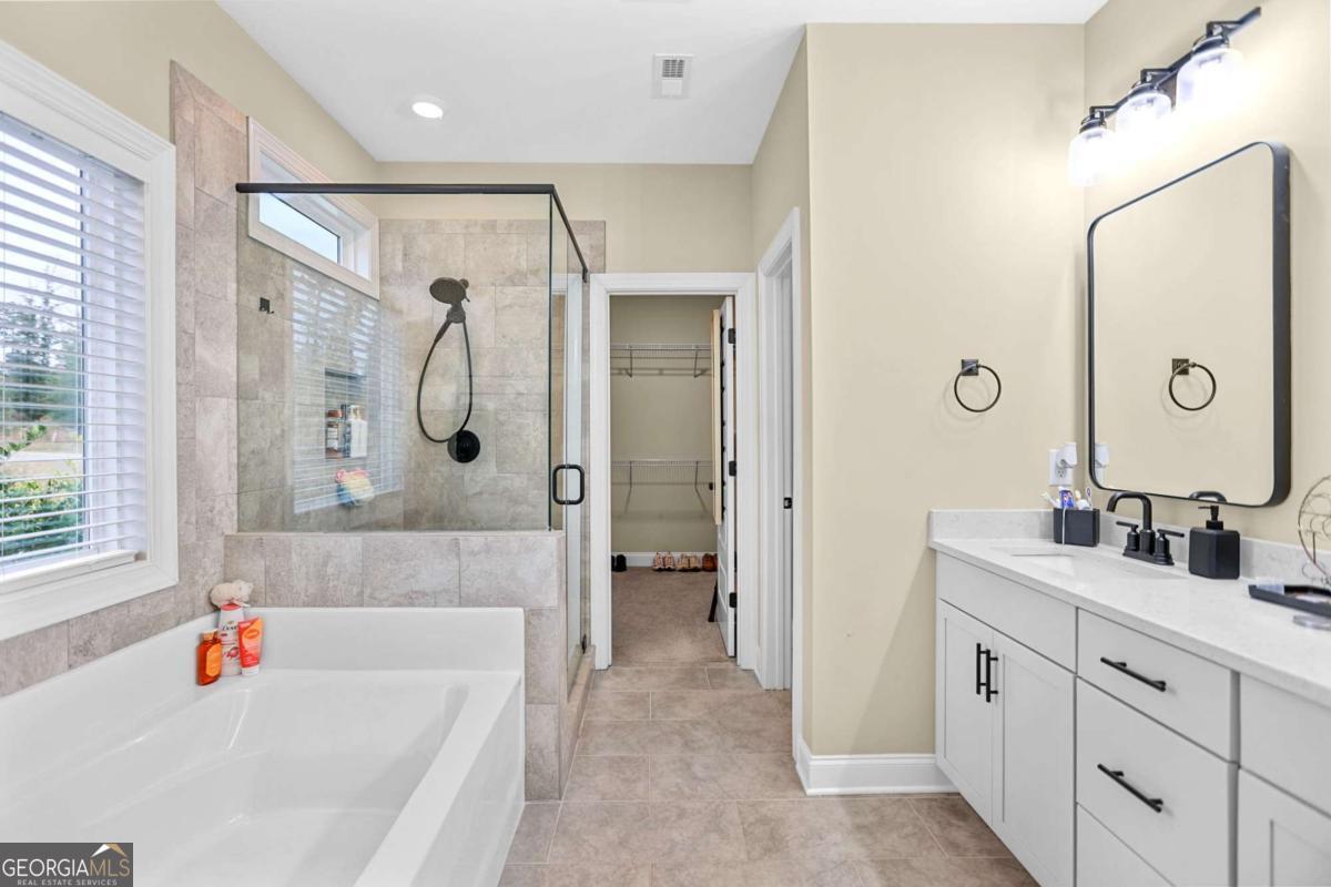 294 Conner Lane Williamson, GA 30292 - Photo 33 of 62 a bathroom with a tub a sink and a large mirror