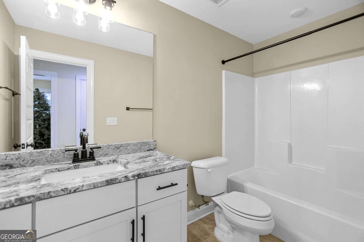 294 Conner Lane Williamson, GA 30292 - Photo 46 of 62 a bathroom with a granite countertop sink toilet mirror and shower